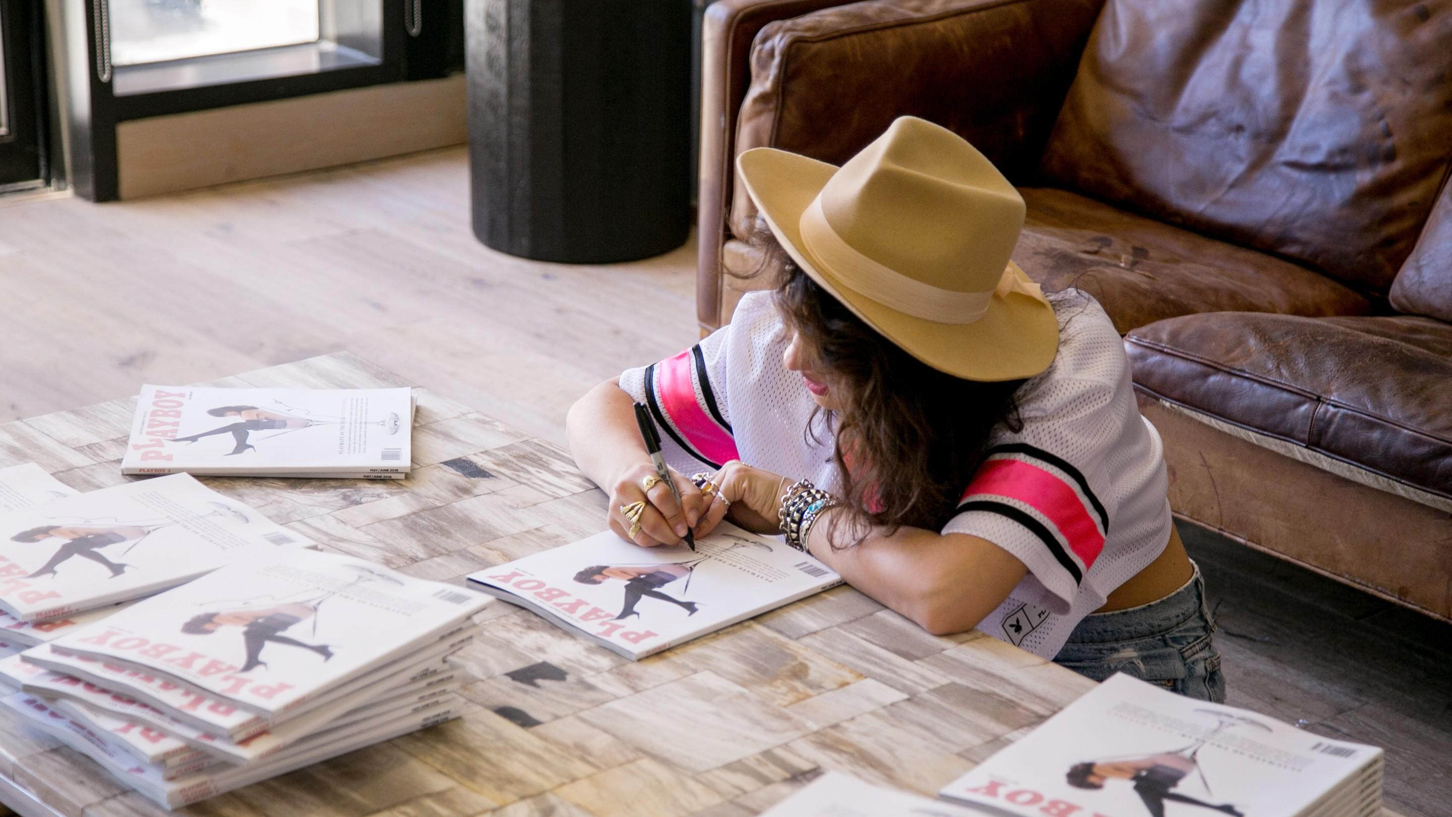 Nina Daniel, Playmate of the Year 2018, signs copies of the issue she appears on.